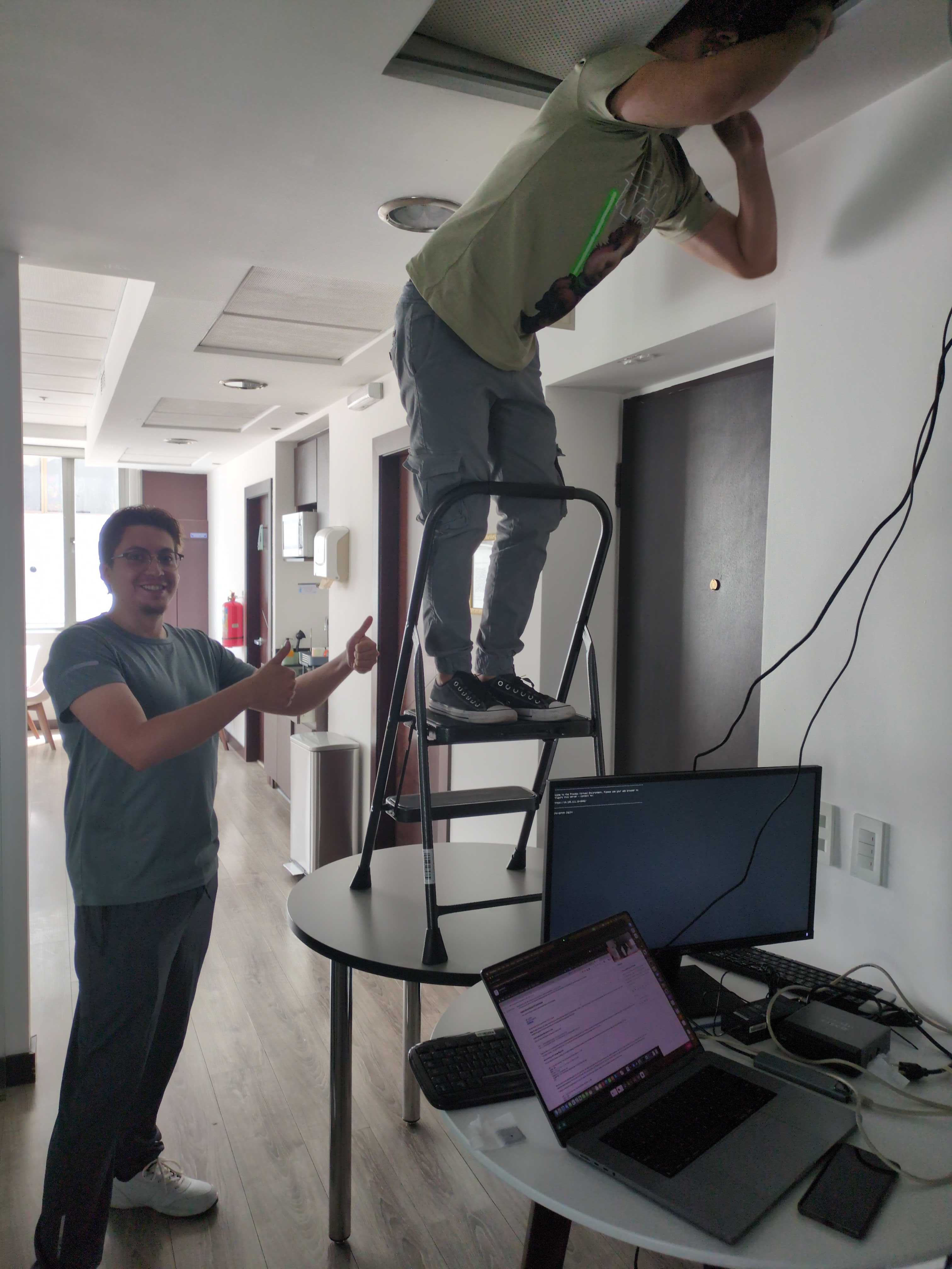 Team installing access point on ceiling